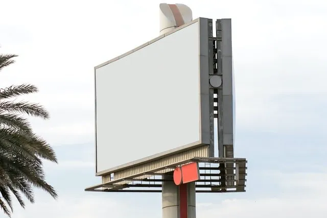 Tall blank white billboard against a blue sky.