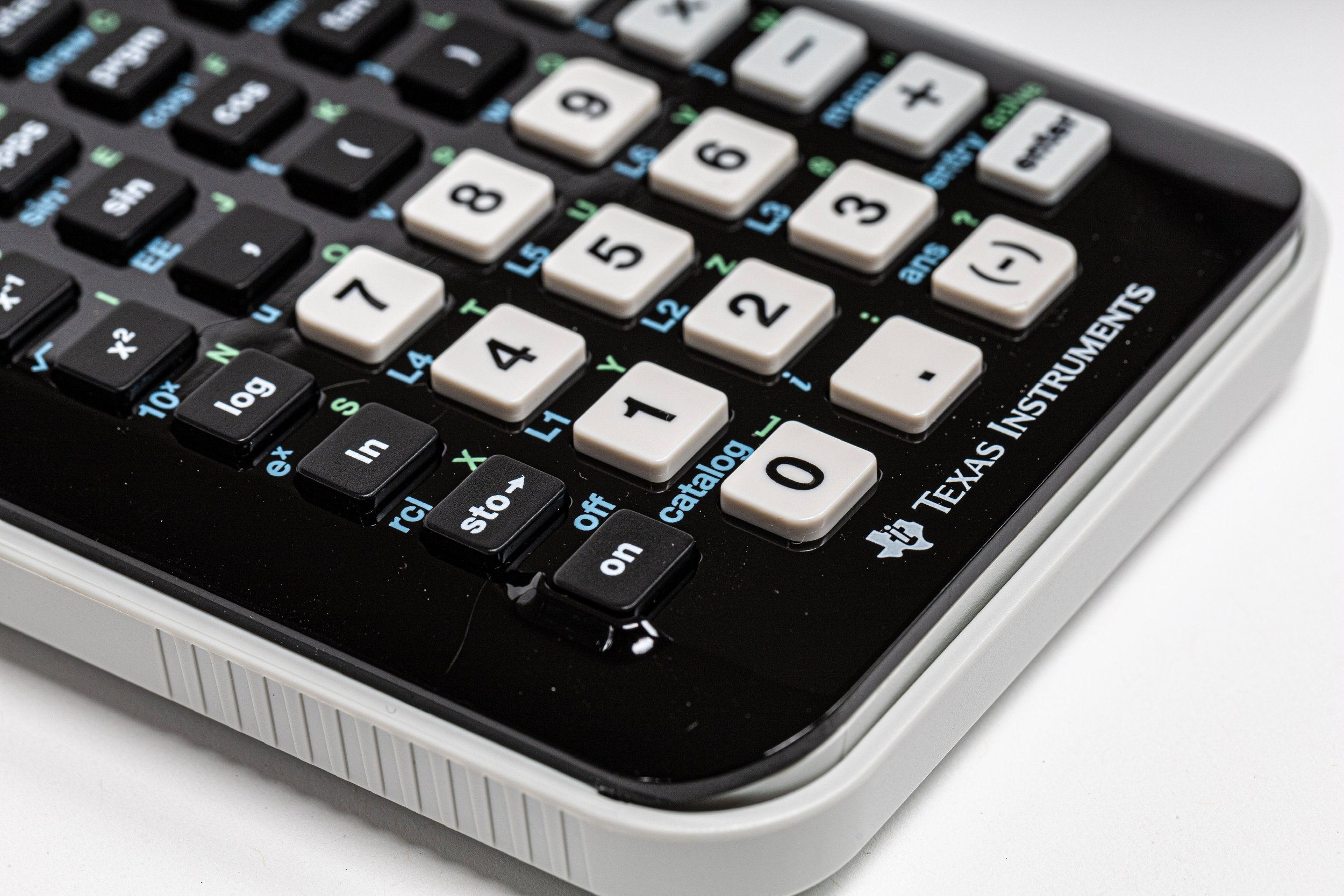 Calculator, pencil, and handwritten budget notes on a wooden desk.
